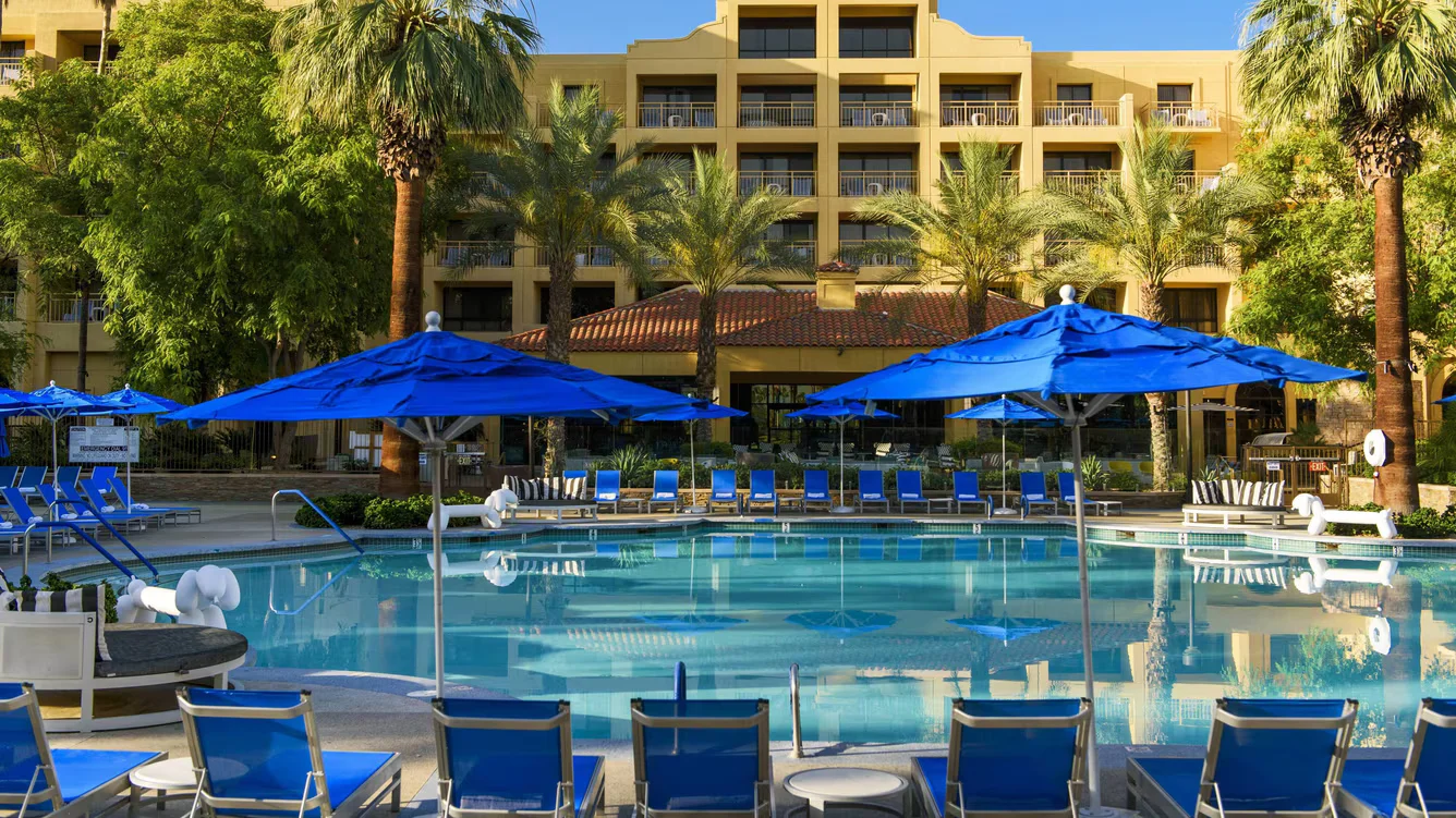 image of an outdoor pool with umbrella tables